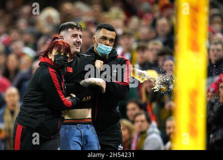 Gli steward rimuovono un fan che invade il campo durante la partita Autumn Internationals al Principality Stadium di Cardiff. Data foto: Sabato 6 novembre 2021. Vedi la storia della Pennsylvania RUGBYU Wales. Il credito fotografico deve essere: David Davies/PA Wire. RESTRIZIONI: L'uso è soggetto a restrizioni. Solo per uso editoriale, nessun uso commerciale senza previo consenso da parte del titolare dei diritti. Foto Stock