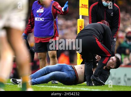 Gli steward rimuovono un fan che invade il campo durante la partita Autumn Internationals al Principality Stadium di Cardiff. Data foto: Sabato 6 novembre 2021. Vedi la storia della Pennsylvania RUGBYU Wales. Il credito fotografico deve essere: David Davies/PA Wire. RESTRIZIONI: L'uso è soggetto a restrizioni. Solo per uso editoriale, nessun uso commerciale senza previo consenso da parte del titolare dei diritti. Foto Stock