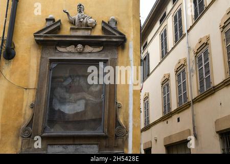 Primo piano di un antico santuario votivo con un affresco della deposizione di Cristo e un'incisione latina nel centro storico di Parma, Emilia-Romagna, Italia Foto Stock