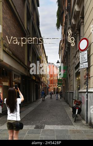 Una strada nel centro storico decorata con un'installazione luminosa con le parole del Va' Pensiero di Giuseppe Verdi, Parma, Emilia-Romagna, Italia Foto Stock