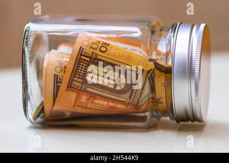 Composizione con banconote in denaro risparmiate in un vaso di vetro Foto Stock