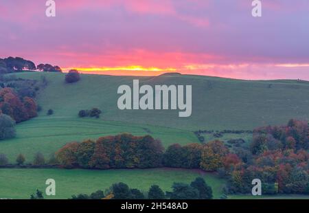Splendido scenario all'alba che si affaccia sul villaggio di Oare e sul vale dal bordo rivolto a sud del Marlborough Downs, adiacente a Pewsey vale, Wiltshi Foto Stock