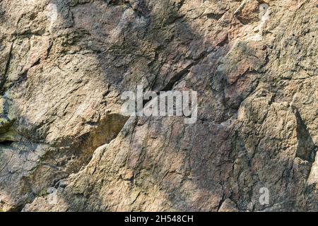 Texture di roccia di granito. Superficie di pietra incrinata dagli agenti atmosferici. Primo piano di superficie di granito. Concetto di colore della terra Foto Stock