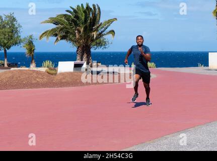 giovane sportivo sano che corre all'aperto in spiaggia Foto Stock