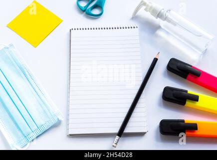 Forniture per la cancelleria scolastica, maschere mediche e igienizzatore per gel per le mani, riapertura scolastica, ritorno a scuola dopo la pandemia di coronavirus di covid-19 è ov Foto Stock