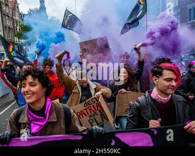 Gli attivisti si vedono ballare in mezzo alle bombe fumé nere e violette durante la manifestazione. la marcia è organizzata dalla Coalizione olandese per la crisi climatica, che è la collaborazione tra undici organizzazioni e gruppi diversi. Questa manifestazione si sta svolgendo contemporaneamente alla Conferenza delle Nazioni Unite sul cambiamento climatico di Glasgow, per chiedere un cambiamento drastico e che il governo olandese agisca ora, sotto forma di politiche climatiche ambiziose ed eque. Questa è stata la più grande manifestazione climatica del paese. Foto Stock