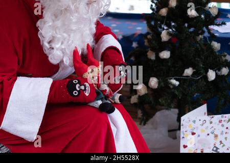 Babbo Natale con giocattoli che giocano per i bambini. Spirito di vacanza e intrattenimento natalizio per bambini. Foto Stock