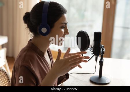 Podcaster femmina che fa podcast audio per il pubblico di internet, primo piano Foto Stock