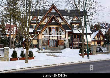Zakopane, Polonia - 21 marzo 2018: La facciata anteriore con tetti spioventi è un moderno edificio alberghiero costruito con l'uso della tradizionale architettura regionale Foto Stock