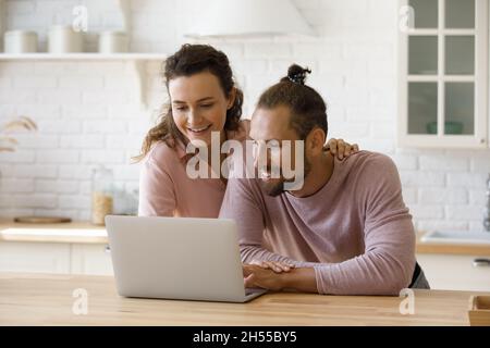 Felice amorevole giovane coppia che usa il computer a casa. Foto Stock