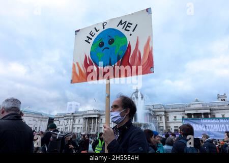 Londra, Regno Unito. 6 novembre 2021. Un manifestante ha visto tenere un cartello con la scritta "aiutami" durante la manifestazione.migliaia di persone hanno marciato dalla Banca d'Inghilterra a Trafalgar Square come parte della Giornata Mondiale d'azione per la Giustizia climatica, mentre i leader mondiali hanno continuato ad incontrarsi a Glasgow per la Conferenza COP26 sul cambiamento climatico. (Foto di Belinda Jiao/SOPA Images/Sipa USA) Credit: Sipa USA/Alamy Live News Foto Stock