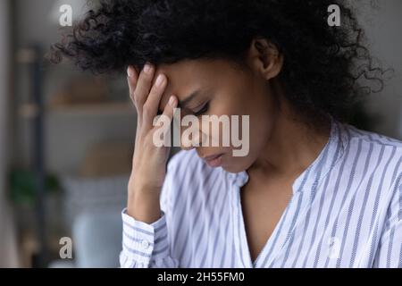 Primo piano infelice depressa afroamericana che tocca la fronte Foto Stock