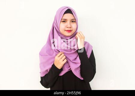 Una donna indonesiana in posa in viola hijab velo Foto Stock