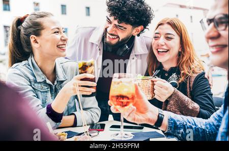 Persone che si divertono a bere al bar all'aperto durante l'happy hour - concetto di stile di vita con i giovani amici che trascorrono del tempo insieme a parlare e condividere cocktail Foto Stock