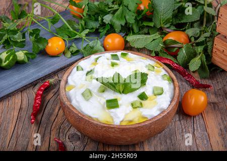 Cacik secco. Tzatziki tradizionale o cacik sul tavolo. Tradizionale antipasto turco cacik, yogurt, aglio e cetrioli e menta su di esso. Foto Stock