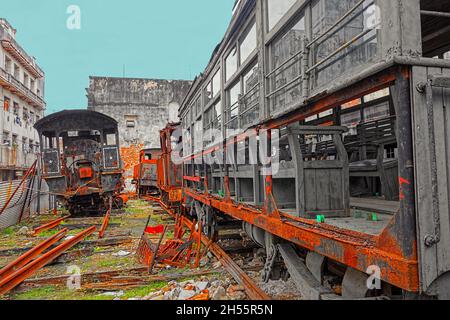 Vecchie locomotive a vapore arrugginite e vagoni merci abbandonate in un cantiere nel centro dell'Avana, Cuba. Foto Stock