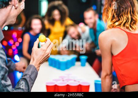 Sfondo sfocato di giovani amici giocando birra pong a ostello della gioventù - concetto di viaggio tempo libero con backpackers che hanno divertimento genuino in pensione Foto Stock