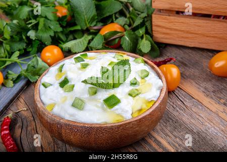 Cacik secco. Tzatziki tradizionale o cacik sul tavolo. Tradizionale antipasto turco cacik, yogurt, aglio e cetrioli e menta su di esso. Foto Stock