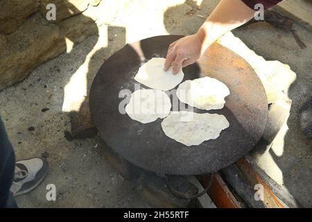 Tava, forno Tabun stufa esterna usata principalmente per la cottura del pane e pitta, forno esterno uso per il modo tradizionale di cottura del pane . Uomo che cuoce un Foto Stock