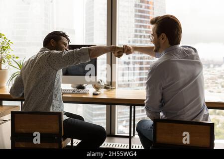 Felice due colleghi maschi gara mista bumping pugni. Foto Stock