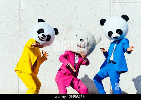 Immagine narrativa di una coppia che indossa una testa panda gigante e abiti colorati. Uomo e donna che fanno festa in un parcheggio. Foto Stock