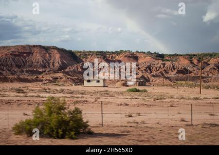 Case in paesaggio di terra arida, foto scattata da auto di guida | edifici ai piedi di colline di arenaria, accelerare vista finestra auto Foto Stock