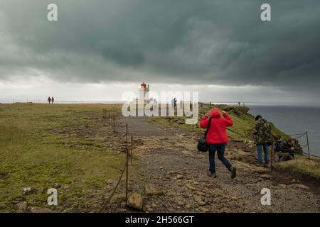 Fotografo a piedi al faro in tempo tempesta Foto Stock