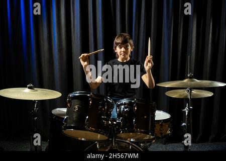 Un ragazzo suona la batteria in uno studio di registrazione Foto Stock