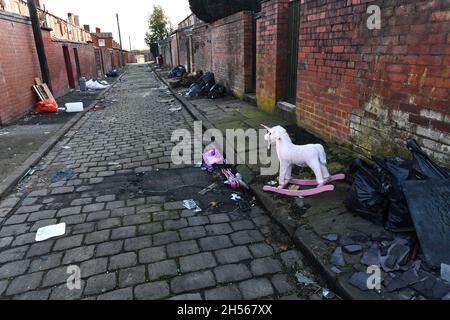 Torna a casa con strade acciottolate cosparse di rifiuti, Bolton, Lancashire Foto Stock