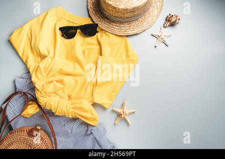 Abbigliamento estivo donna, t-shirt gialla, pantaloncini, occhiali da sole a cappello, accessori. Vista dall'alto, disposizione piatta. Collezione primavera estate Foto Stock