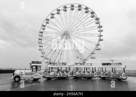Immagine in bianco e nero della ruota panoramica e del mini treno sotto la pioggia a Saint-Raphael, Var, Costa Azzurra, Francia. Foto Stock