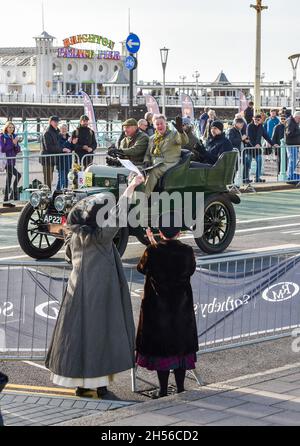 Brighton, Regno Unito. 7 novembre 2021. Brighton UK 7 novembre - Una giovane donna ondeggia come veicoli vicino al traguardo del RM Sotheby's London to Brighton Veteran Car Run Today . Quest'anno è il 125° anniversario della BritainÕs edizione del motoring più lunga: Credit Simon Dack/Alamy Live News Foto Stock