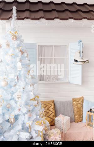 Albero di Natale bianco decorato con palle di Natale rosa dorato argento e belle palle di vetro su branca blu brillante e fata, decorativo Foto Stock