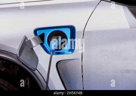 Primo piano di un veicolo alimentato da una presa elettrica. Foto Stock