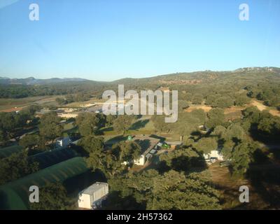 Ascari Race Resort: Vista panoramica aerea del circuito, giorno di sole, con montagne sullo sfondo. Foto Stock