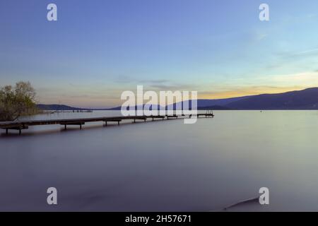 Un molo di legno sul tramonto drammatico Foto Stock