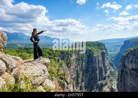 Donna tranquilla in piedi sulla scogliera Foto Stock