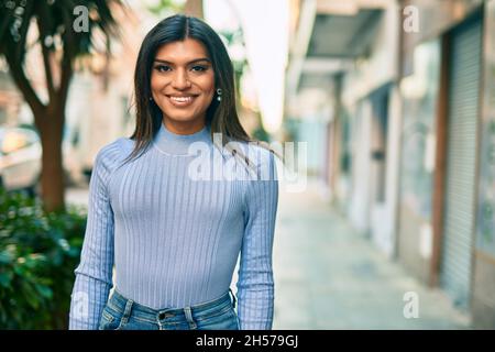 Bella donna ispanica sorridente confidente in città Foto Stock