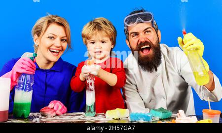 La famiglia pulisce insieme allo spray detergente. Tempo di pulizia della casa. Madre padre e figlio con i rifornimenti di pulizia. Foto Stock