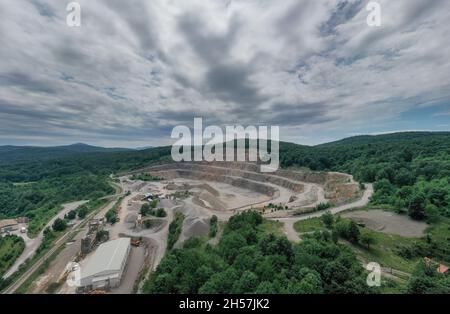 Cava di pietra in Croazia, Europa. Vista aerea della cava mineraria Opencast con molti macchinari. Vista dall'alto. Industria mineraria del marmo. Foto Stock