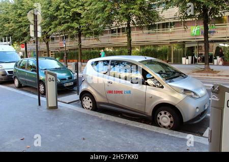 Stazione di ricarica per auto elettriche, che alimenta un'auto per le strade di Parigi, Francia. Foto Stock