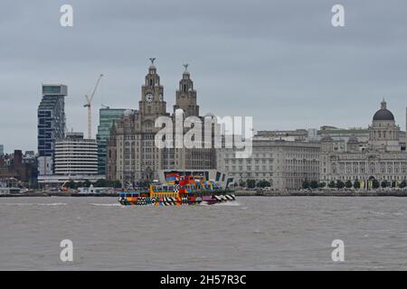Il traghetto MV Snowdrop Mersey in livrea Razzle Dazzle visto passando il Royal Liver Building a Liverpool, Regno Unito Foto Stock