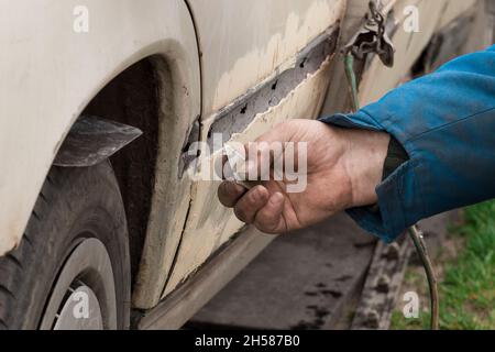 Riparazione della portiera posteriore della vettura. Eliminazione del corpo di trasporto rotto. Foto Stock