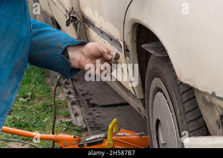 Riparazione della portiera posteriore della vettura. Eliminazione del corpo di trasporto rotto. Foto Stock