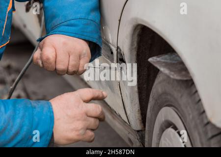 Riparazione della portiera posteriore della vettura. Eliminazione del corpo di trasporto rotto. Foto Stock