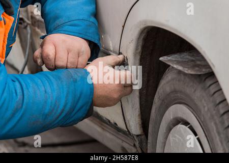 Riparazione della portiera posteriore della vettura. Eliminazione del corpo di trasporto rotto. Foto Stock