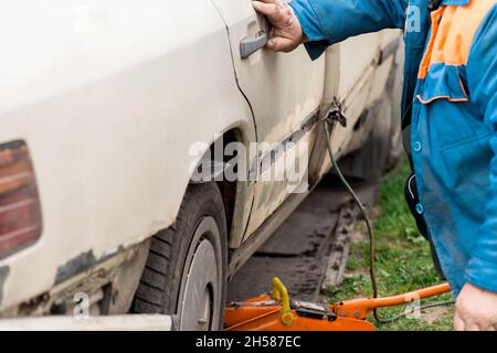 Riparazione della portiera posteriore della vettura. Eliminazione del corpo di trasporto rotto. Foto Stock