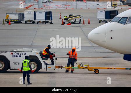 Due operatori aeroportuali discutono durante il traino di un grande aeromobile 747 Foto Stock