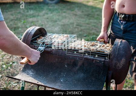 spiedini di carne alla griglia pollo il portaraffè sopra fuoco bruciò churcoal Foto Stock