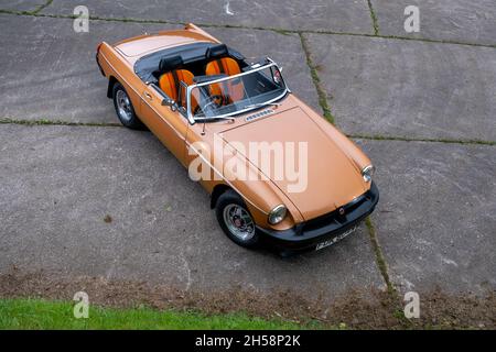 MGB Roadster edizione limitata in bronzo parcheggiato su un molo di cemento vicino ad un piccolo lago Foto Stock